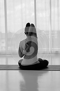 female doing stretching exercises yoga. Hands behind back, sitting in Vajrasana pose with hands hooked behind the back.