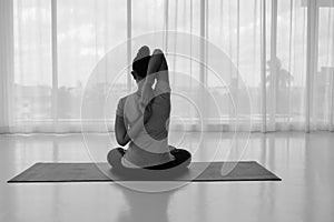 Female doing stretching exercises yoga. Hands behind back, sitting in Vajrasana pose with hands hooked behind the back.