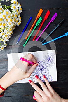 Female drawing flower shapes in notebook