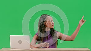 Female in dress sit at the desk isolated on chroma key green screen background. African american woman tv news host