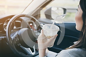 Female drinking coffee while driving