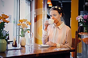 Female drinks coffee in a cafe.