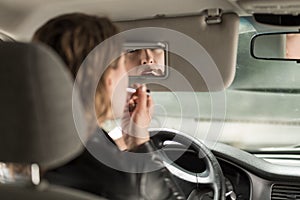 Female driver applying lipstick