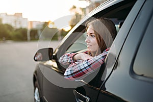 Female driver beginner looks out of the car window