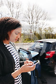 Female Driver Contacting Car Insurance Company On Mobile Phone After Road Traffic Accident