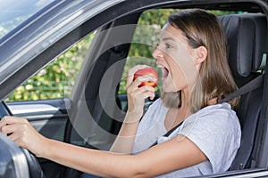 female driver eating apple