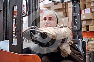 Female driver of forklift working at warehouse