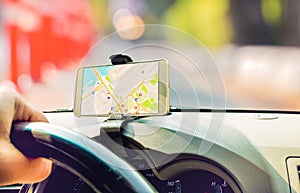 Female driver sitting in the car use mobile smart phone with map gps navigation application