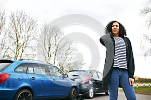 Female Driver With Whiplash Injury Standing By Damaged Car After Road Traffic Accident