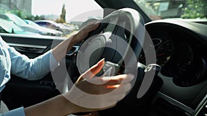 Female driving car back into parking spot, attentive driver closeup reverse gear