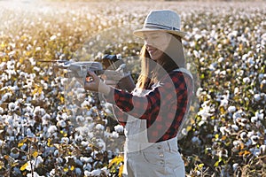 The female drone pilot walks into the field and inspects before the flight.