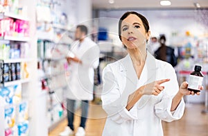 Female druggist presenting medicine in drugstore