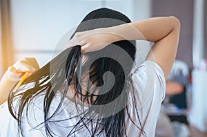 Female drying long hair with dryer,Young asian woman after bath hairbrushing her hair with comb