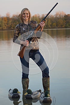 Female Duck Hunter with shotgun and decoys