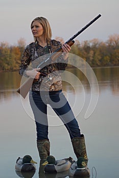 Female Duck Hunter with shotgun and decoys photo
