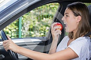 female eating apple inside car