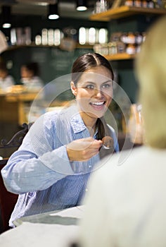 Female eating a chocolate truffle in a cafe