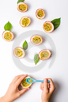 Female eating Passion fruit with a spoon