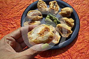 Female eating serving delicious Bread Pakoda or Bread friitters stuffed with potato curry and dipped with gramflour coating