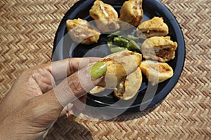 Female eating serving delicious Bread Pakoda or Bread friitters stuffed with potato curry and dipped with gramflour coating