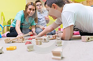 Female educator teaching children to build a train circuit photo