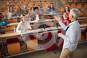 Female elderly professor answering student`s questions