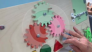 Female elderly women spin colorful wooden circles on a board to restore motility after a previous illness