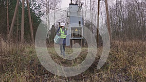 Female electrical engineer finishing checking low voltage line with transformer