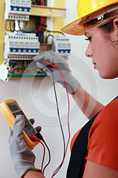 Female electrician checking fusebox