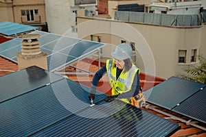 Female electrician engineer installing photovoltaic Solar Panels on city rooftop