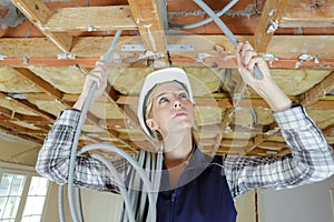 Female electrician fixing ceiling lighting