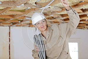 Female electrician fixing ceiling lighting