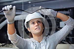 female electrician fixing ceiling wiring