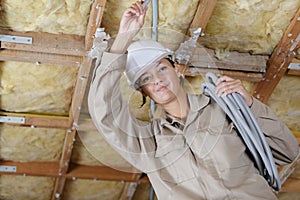 Female electrician holding cables indoors