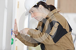 Female electrician installing wall socket