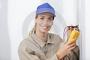 female electrician repair outlet on wall