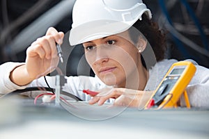female electrician testing charge to spotlight