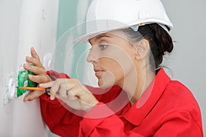 Female electrician testing wall socket