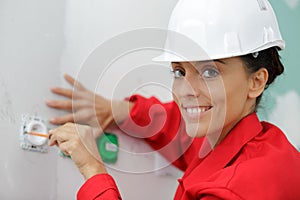female electrician testing wall socket