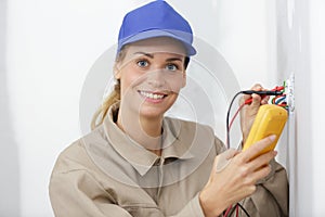 female electrician testing wall socket