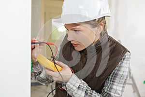 Female electrician testing wall socket