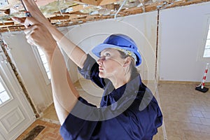 female electrician wiring inside ceiling