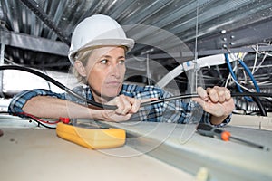 Female electrician working on false ceiling
