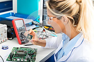 Female electronic engineer checking CPU microchip in laboratory