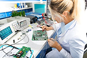 Female electronic engineer testing computer motherboard in labor photo