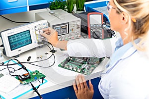 Female electronic engineer using oscilloscope in laboratory photo