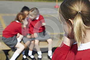 Female Elementary School Pupils Whispering In Playground