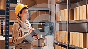 Female employee checking list of products in depot