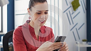 Female employee checking text messages on smartphone