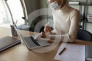 Female employee in face mask disinfect workplace